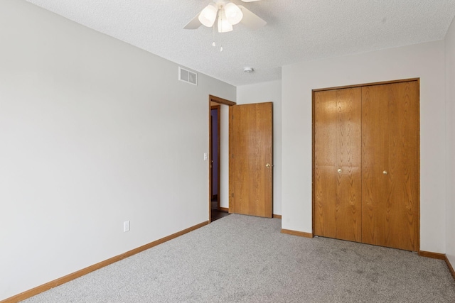 unfurnished bedroom with visible vents, carpet floors, baseboards, and a closet