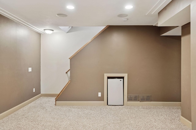 below grade area featuring stairs, carpet flooring, recessed lighting, and visible vents