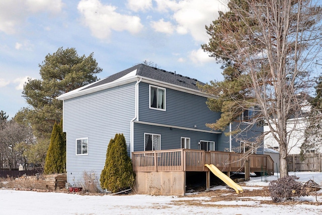 snow covered house featuring a wooden deck