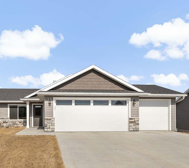 view of front of property featuring stone siding, concrete driveway, and an attached garage