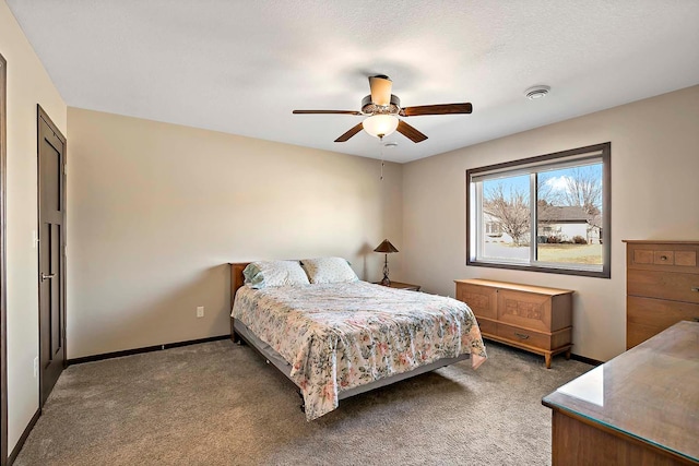 bedroom with ceiling fan, baseboards, a textured ceiling, and light colored carpet