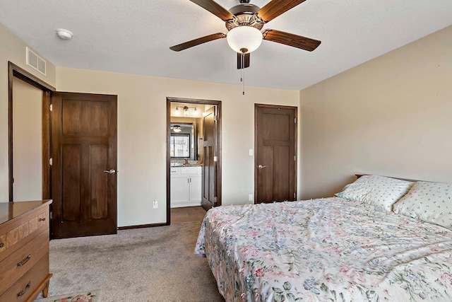 carpeted bedroom featuring baseboards, visible vents, ceiling fan, and connected bathroom