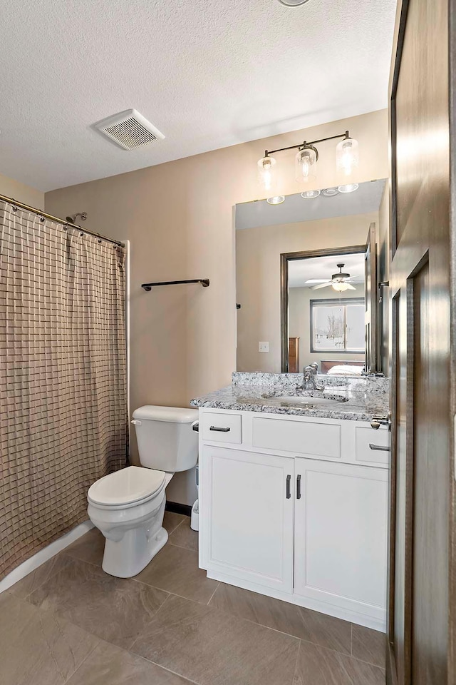 bathroom featuring a textured ceiling, toilet, vanity, visible vents, and a ceiling fan