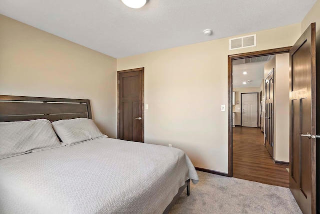 carpeted bedroom featuring visible vents and baseboards