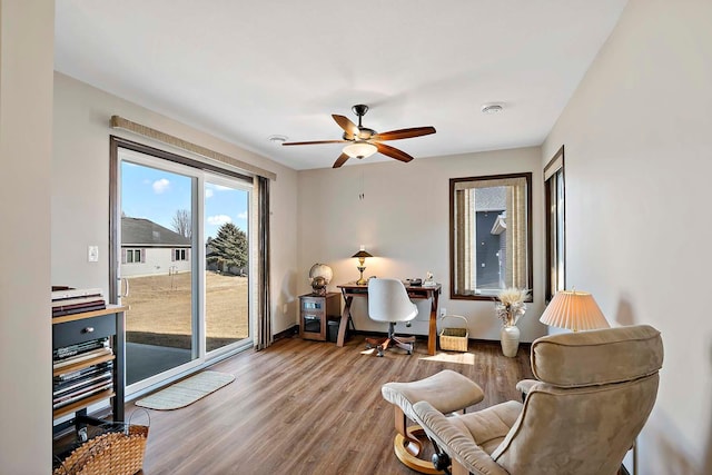 sitting room with wood finished floors, a ceiling fan, and baseboards