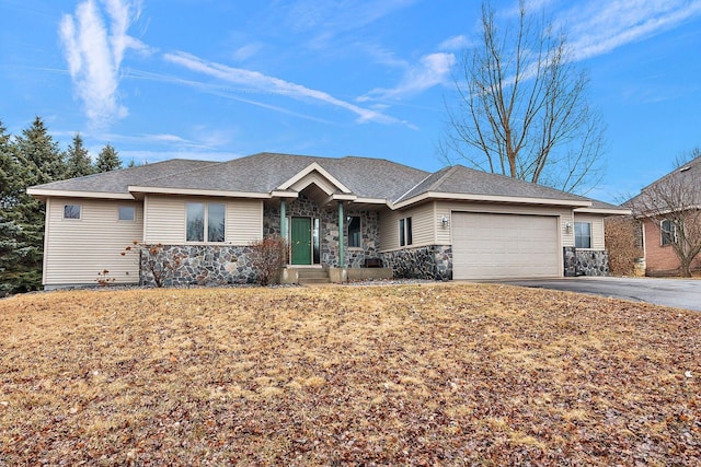 ranch-style house featuring an attached garage, stone siding, driveway, and a shingled roof