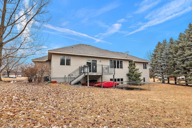 back of house with stairway, roof with shingles, and a deck