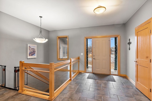 entryway with stone finish floor and baseboards