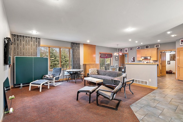 living room featuring a barn door, recessed lighting, and visible vents