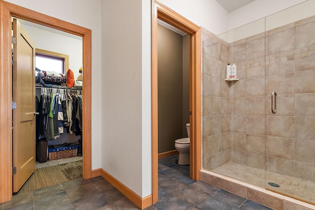 full bath with a shower stall, stone finish floor, toilet, and baseboards