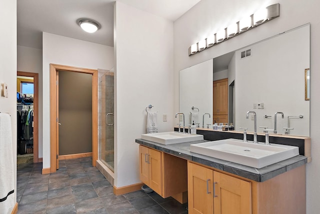 full bath with visible vents, a shower stall, baseboards, and a sink