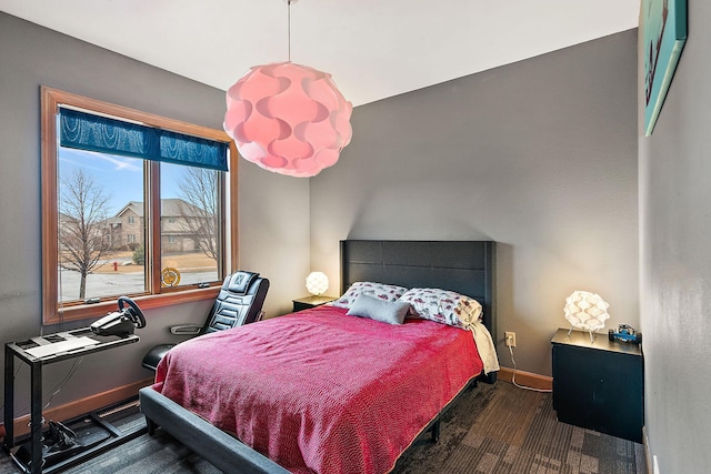 bedroom with baseboards and wood finished floors