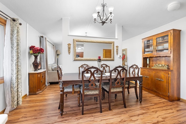 dining area featuring light wood-type flooring and a notable chandelier