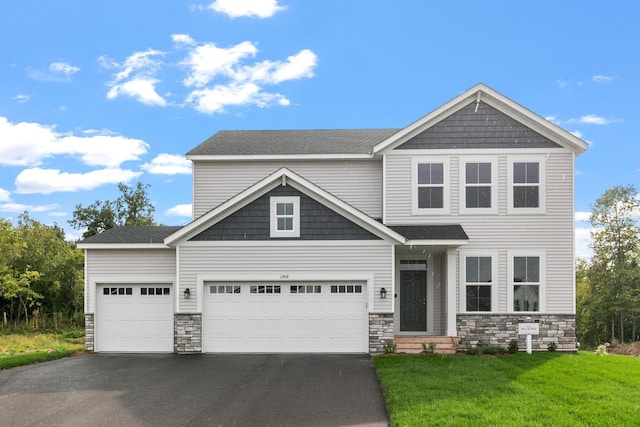 craftsman house with aphalt driveway, a front yard, and stone siding