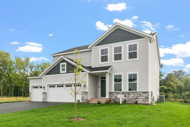 view of front of property with central AC unit, a front yard, a garage, stone siding, and driveway