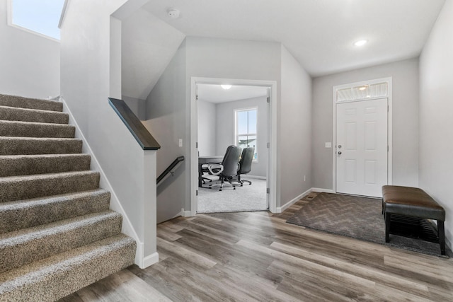 foyer featuring stairs, baseboards, and wood finished floors