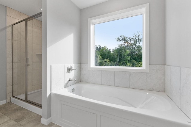 bathroom with a stall shower and a garden tub