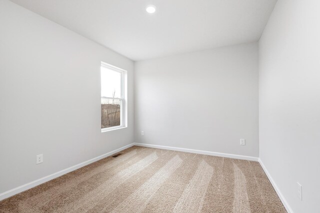 unfurnished room featuring light carpet, visible vents, baseboards, and recessed lighting