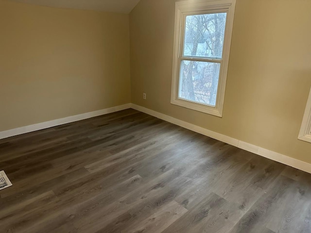 bonus room featuring dark wood-type flooring and baseboards