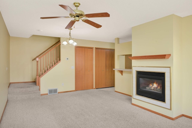 unfurnished living room featuring stairway, carpet flooring, visible vents, and baseboards