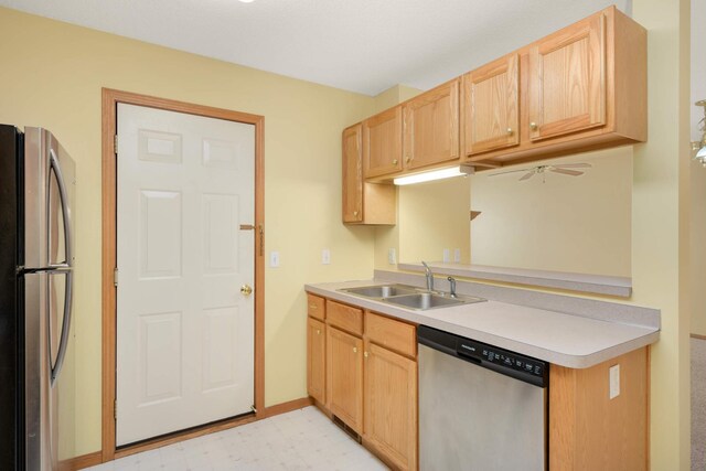 kitchen featuring light countertops, stainless steel appliances, light brown cabinetry, light floors, and a sink