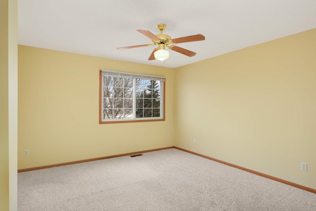 spare room with ceiling fan, carpet, visible vents, and baseboards