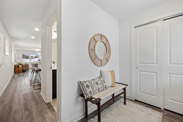 corridor with baseboards, wood finished floors, and recessed lighting