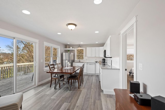 dining space with recessed lighting, baseboards, and light wood finished floors