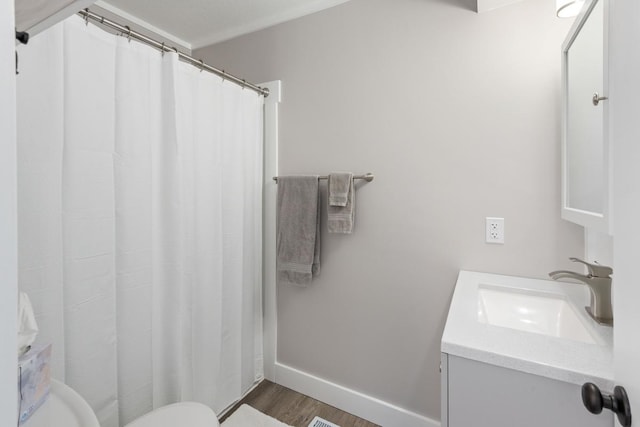 full bathroom with vanity, a shower with curtain, wood finished floors, baseboards, and toilet