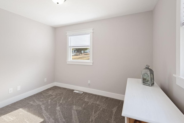 empty room with visible vents, carpet, and baseboards