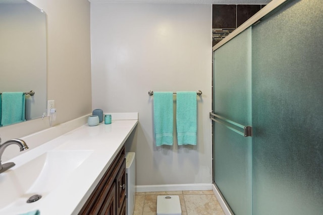 bathroom featuring a stall shower, vanity, and baseboards