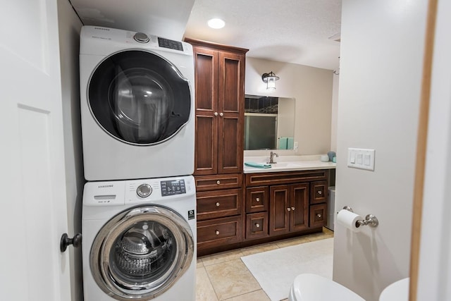 clothes washing area with light tile patterned floors, laundry area, stacked washer / drying machine, and a sink