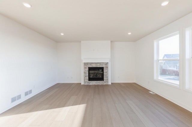 unfurnished living room featuring recessed lighting, visible vents, a fireplace, and light wood-style flooring