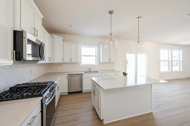 kitchen with stainless steel appliances, light wood-type flooring, and white cabinets