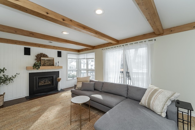 living room featuring beamed ceiling, recessed lighting, and a glass covered fireplace