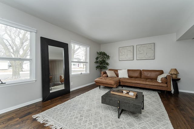 living room featuring baseboards and dark wood-type flooring