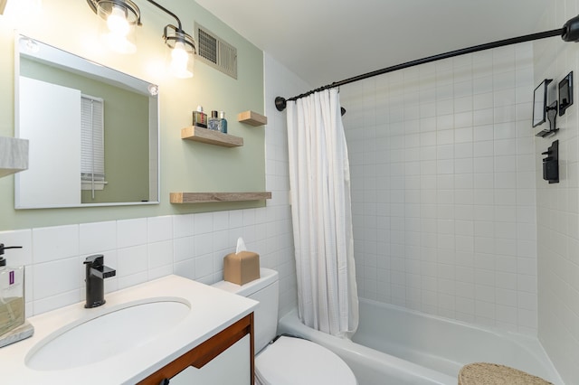 bathroom featuring vanity, visible vents, shower / bath combo, tile walls, and toilet