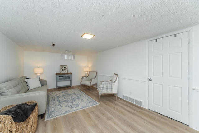 living area featuring wood finished floors and visible vents