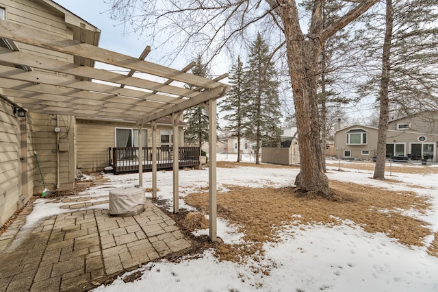 yard covered in snow with fence and a pergola