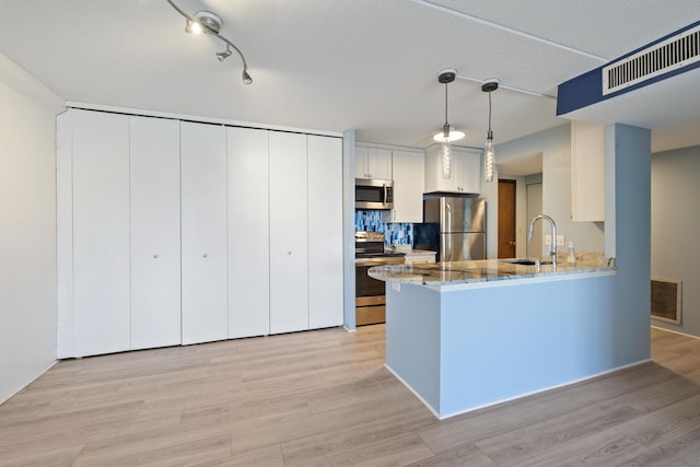 kitchen featuring light wood finished floors, visible vents, appliances with stainless steel finishes, and a sink