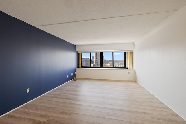 spare room featuring a city view and wood finished floors