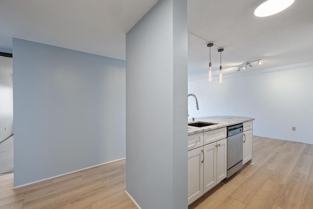 kitchen with dishwasher, white cabinets, light wood finished floors, and a sink