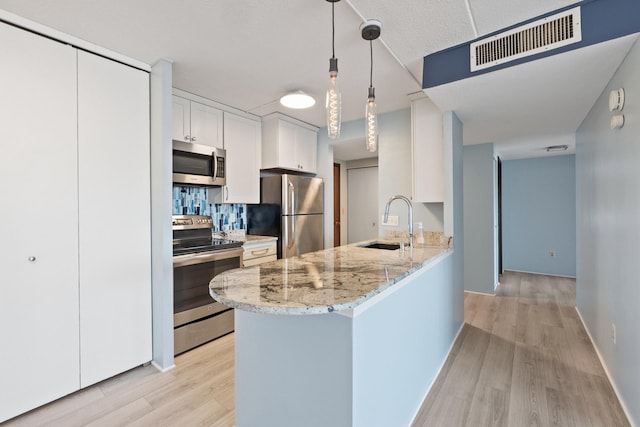 kitchen with visible vents, a sink, light wood-style floors, appliances with stainless steel finishes, and white cabinetry