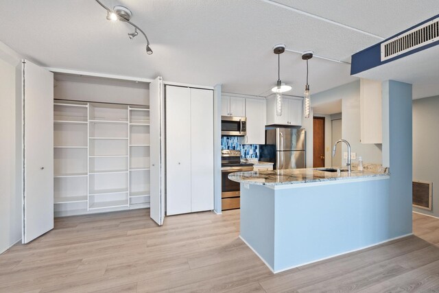 kitchen with a sink, visible vents, light wood-style floors, and appliances with stainless steel finishes