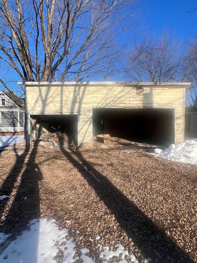 snow covered structure featuring a carport