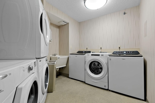 laundry room with a sink, washer and clothes dryer, and a textured ceiling