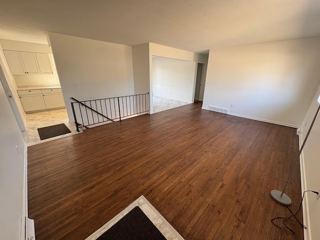 unfurnished room featuring visible vents, baseboards, and wood finished floors