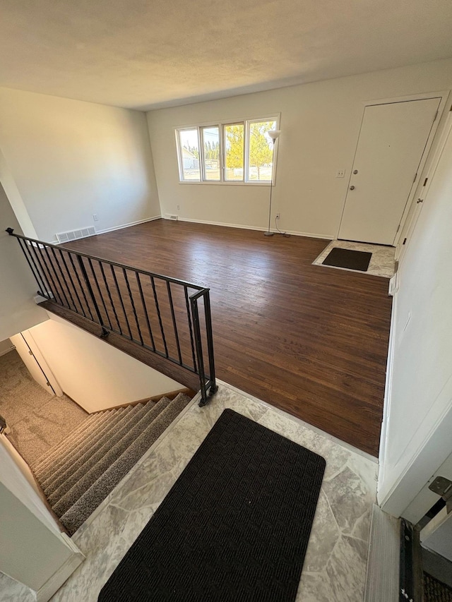 interior space with wood finished floors, visible vents, and baseboards