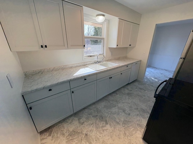 kitchen featuring a sink, freestanding refrigerator, white cabinetry, black range oven, and dishwasher