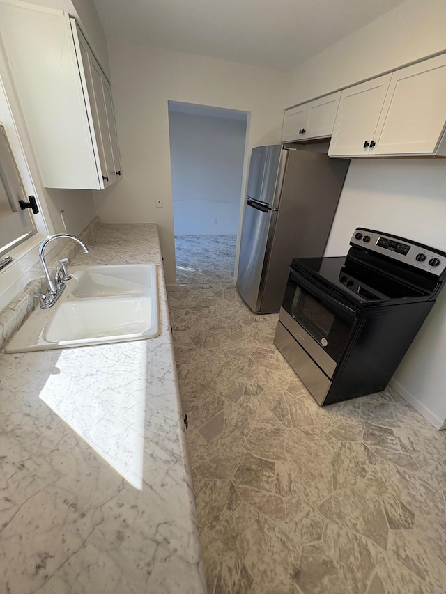 kitchen with white cabinetry, light countertops, appliances with stainless steel finishes, and a sink